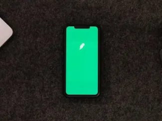 A phone resting on a wooden desk, showcasing the app of a financial business
